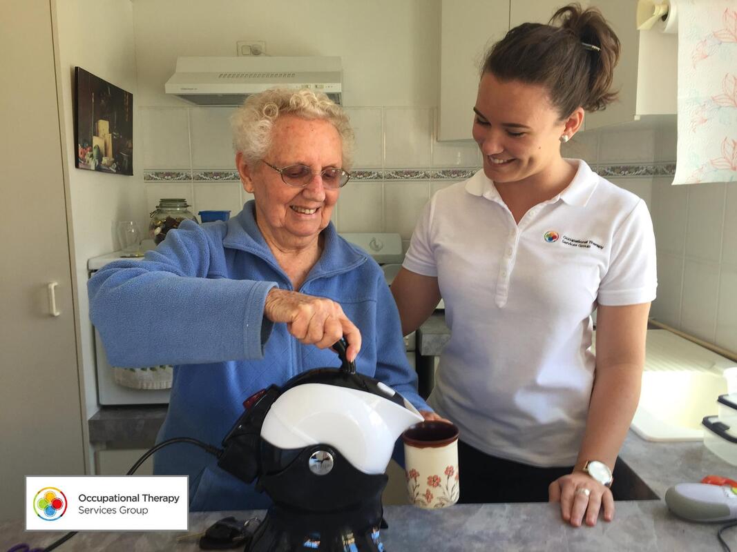 Picture of client using a kettle tipper with her Occupational Therapist standing on her left